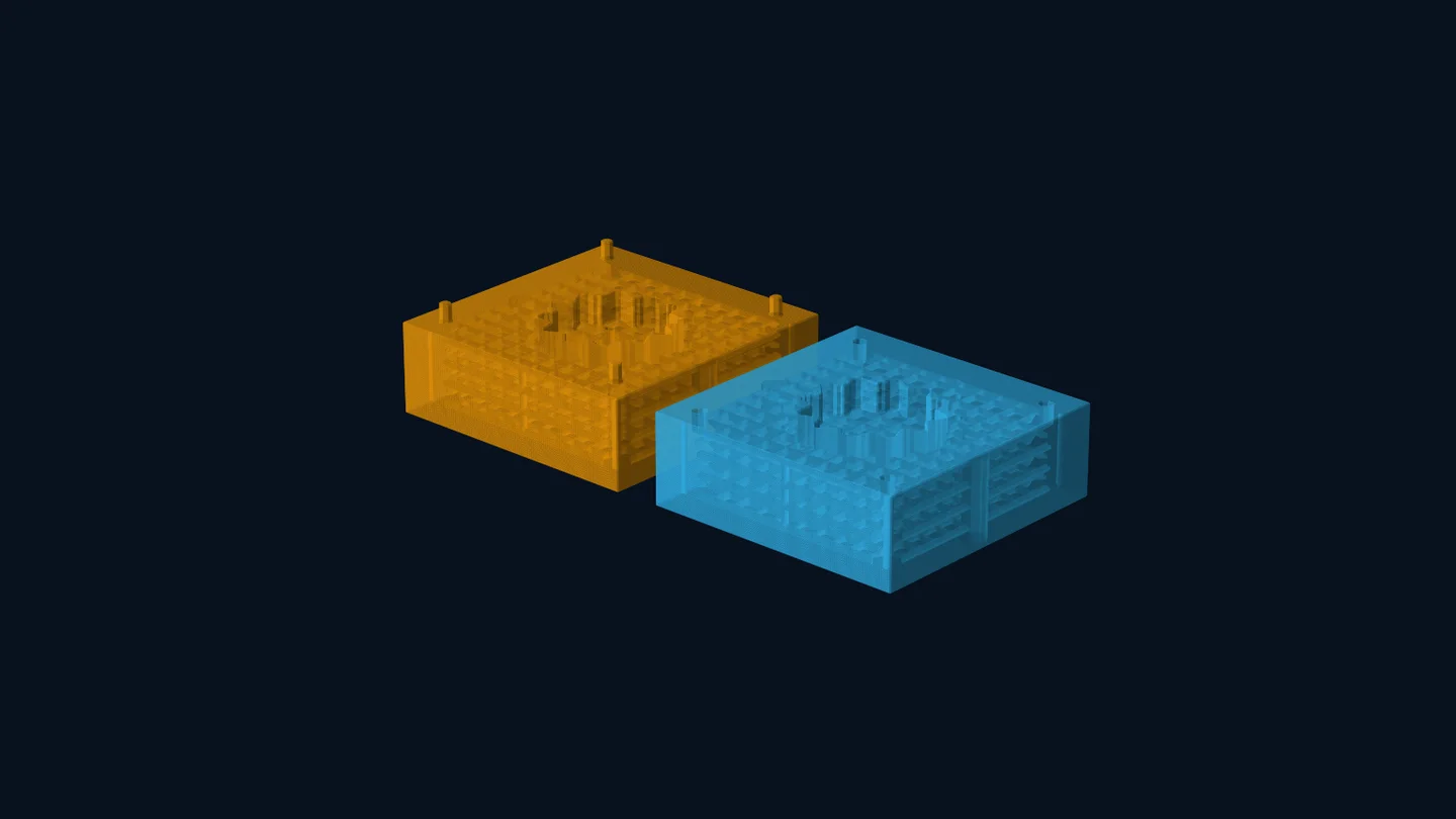 Separated orange and blue mold halves with internal channel geometry and visible port features.